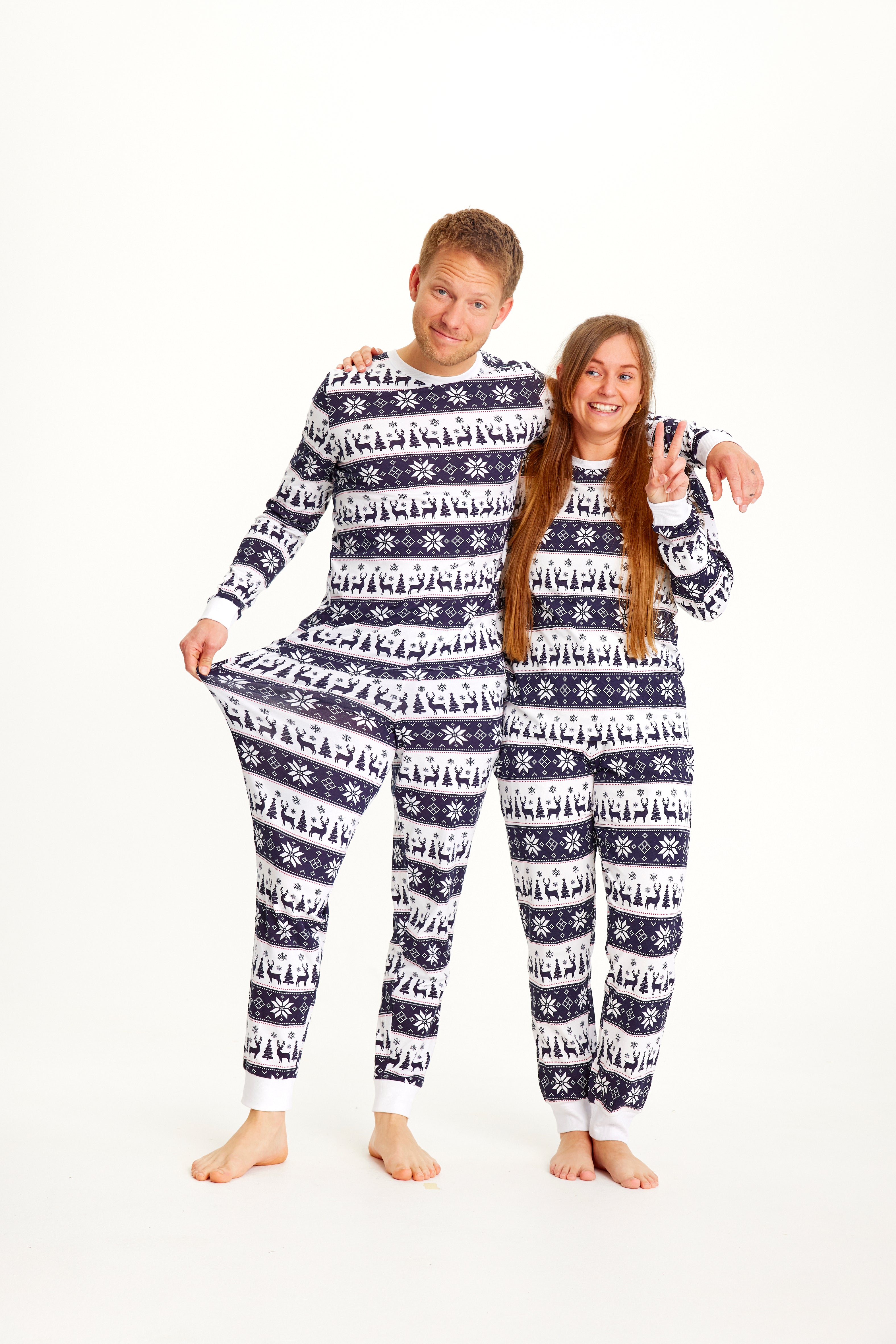 Een stel dat samen poseert in een blauw-wit gestreepte kerstpyjama.